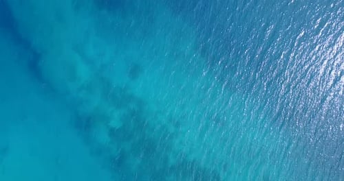 Daytime drone travel shot of a paradise sunny white sand beach and aqua blue ocean background in col