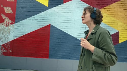 Pretty Millennial Girl Put on Headphones Outside