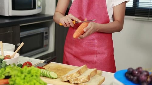 Woman Prepares Vegetables for Salad in Kitchen
