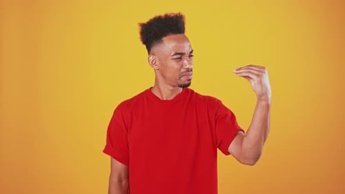 African American Man Showing Bla Bla Gesture with Hand and Shaking Head No Orange Studio Background