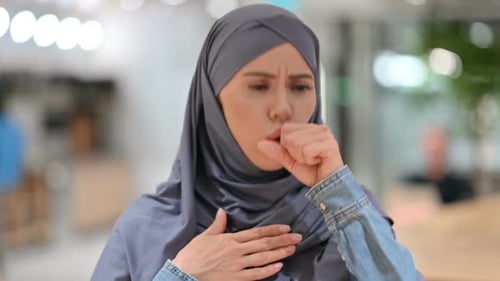 Woman in Headscarf Coughing Indoors
