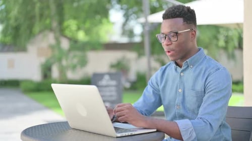 Young Adult on Video Call With Laptop Outside