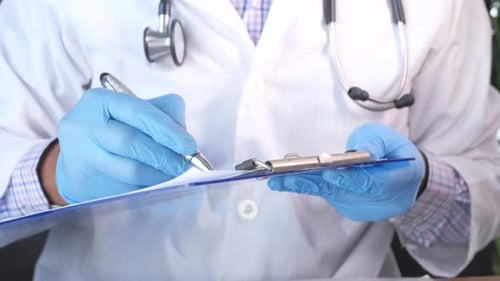 Doctor Hand Writing Prescription on Desk, Close Up