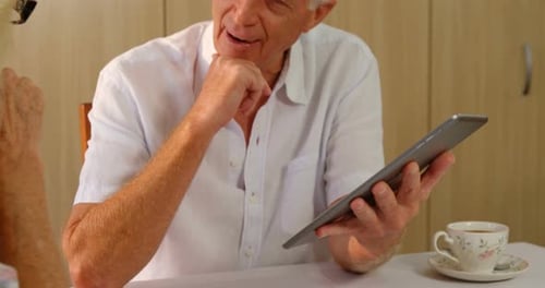 Mature Couple Discussing Content on Tablet Device