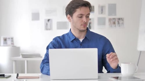 Lässiger erwachsener Mann trinkt Kaffee während der Arbeit am Laptop