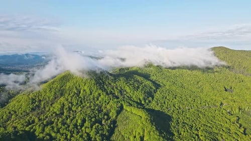 Fabulous Landscape From a Height on the Clouds Moving on Top of a Mountain Covered with Green