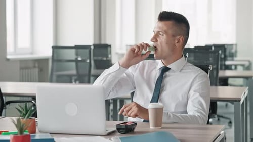 Man Eating Lunch at Office Desk