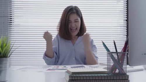 junge asiatische Frau arbeitet am Laptop, während sie in einer lebenden Geschäftsfrau sitzt, die in ihrem Haus arbeitet.