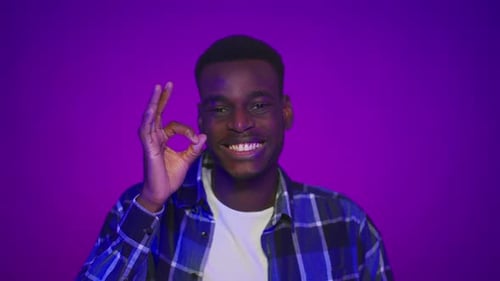 Smiling Young Man Giving 'OK' Hand Gesture
