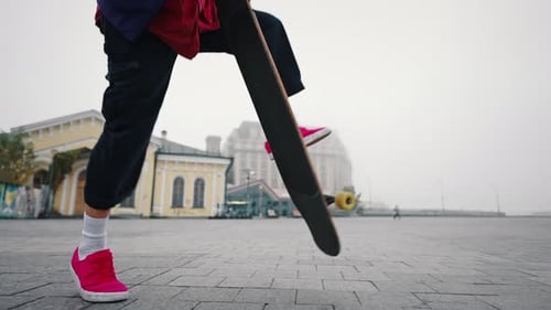 Young Man Doing Skateboard Ollie in City Square