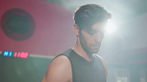 Caucasian athlete man bodybuilder put on boxing glove in hands, ready to exercise at fitness gym.