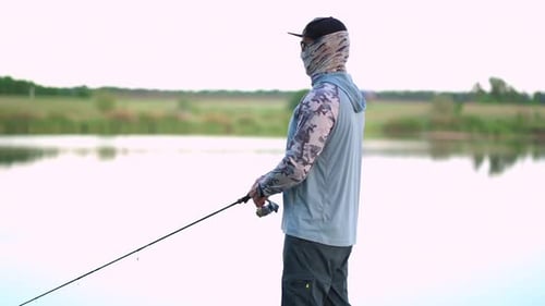 The Fisherman Sportsman Catches a Predatory Fish on a Spinning on the Lake