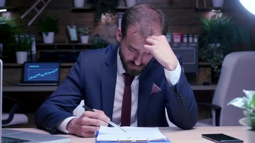 Zoom in Shot do empresário cansado e exausto trabalhando tarde da noite no escritório