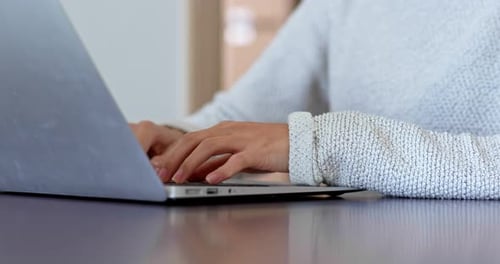 Person Typing on Laptop Computer at Desk