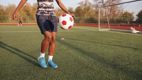 Woman Practicing Soccer Skills on Sunny Field