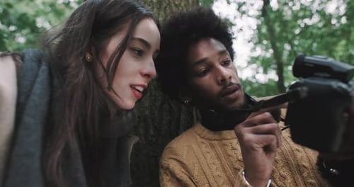 Woman and Man Looking at Camera in Forest