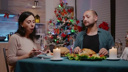 Casal tilintando taças de champanhe na ceia de Natal