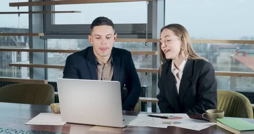 Man and a Woman Discussing Work in the Brightly Lit Modern Office. Concerned Male and Female Working