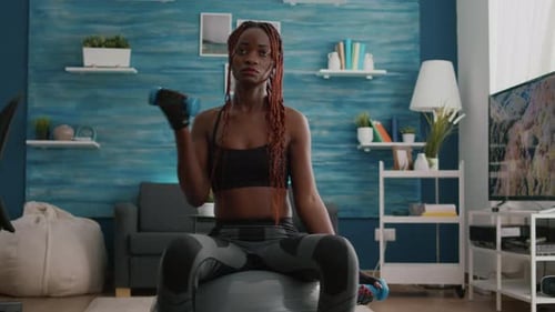 Woman Sitting on Fitness Ball Doing Dumbbell Curls