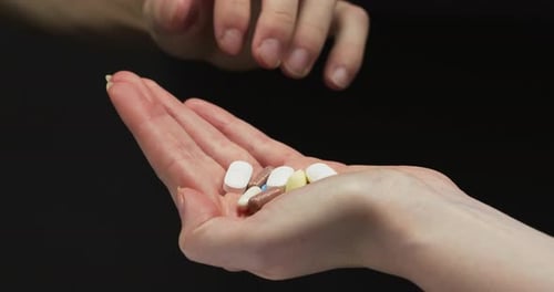 Taking a pill from hand