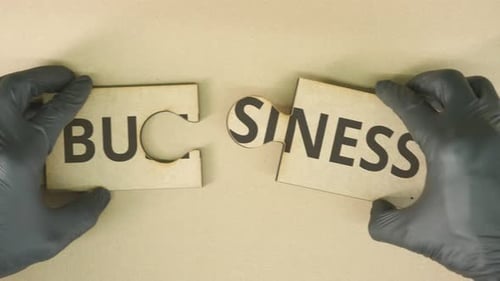 Hands Completing Business Puzzle with Word