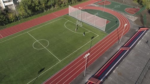 People play sports at the stadium in the yard in the city. Aerial 12