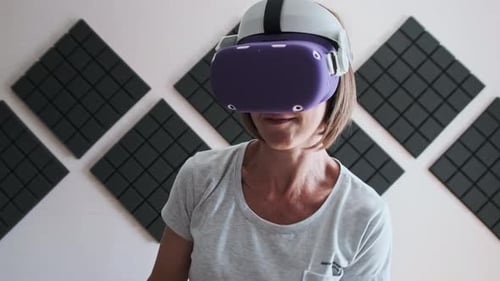 Woman Wearing Virtual Reality Headset Holding Controllers