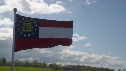 Realistic Waving Georgia State Flag Against Blue Sky
