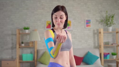 Woman Poses with Therapeutic Tape on Arm
