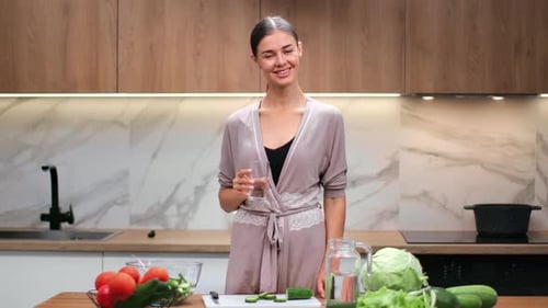 Woman Smiling Holding Water in Modern Kitchen