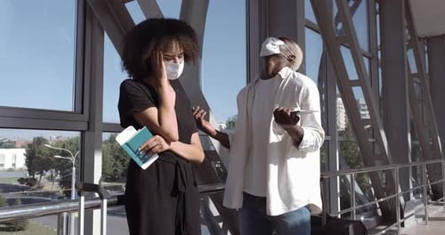 Young Couple Standing with Travel Documents in Airport