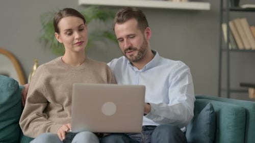 Couple Using Laptop Together on Couch at Home