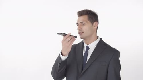 Man in Suit Speaking into Smartphone on White