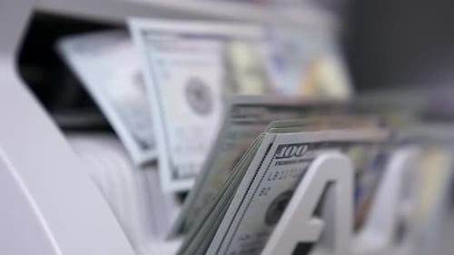Money Counter Counts Stack of United States Currency