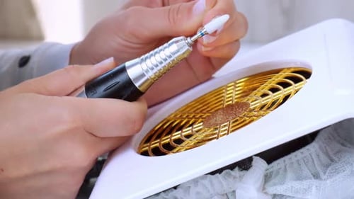 Woman Filing Nails with Electric Nail File Close Up