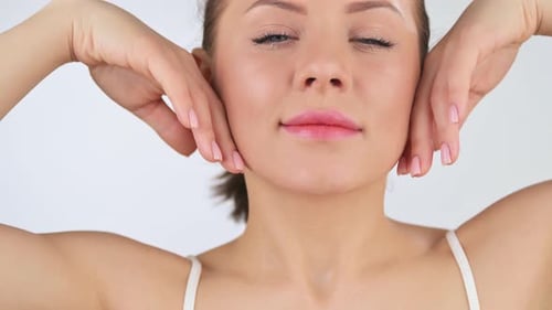 Woman Massaging Face with Hands Close Up