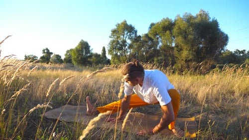 Close Up of Sporty Guy Practicing Yoga Moves and Positions on Mat at the Field