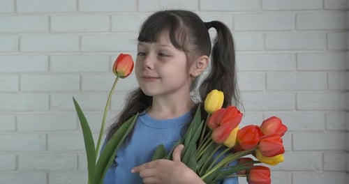 Happy Girl Smelling Red and Yellow Tulip Bouquet