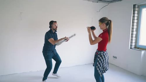Woman Filming Man Playing with a Level