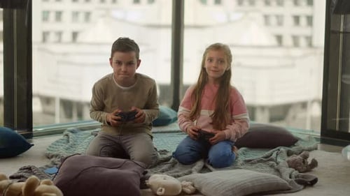 Siblings Playing Computer Games. Kids Holding Gamepads in Living Room.