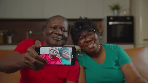 Senior Couple Filming Video Together with Smartphone at Home