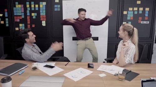 Joyful Colleagues Celebrate Success with Dance in Office