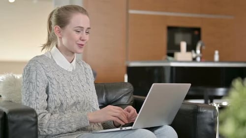 Young Woman Doing Video Chat on Laptop at Home