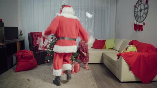 Santa Claus and Child Dancing Around Christmas Tree