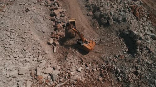 Excavator Filling Dump Truck in Rock Quarry
