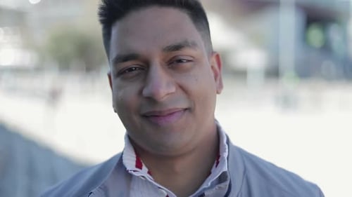 Man Smiling Confidently in an Urban Setting