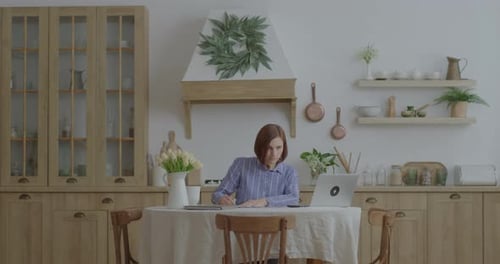 Young Woman Working at Home in Kitchen