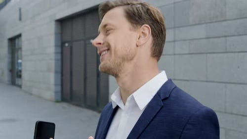 Excited Man Celebrates Good News on Phone in City