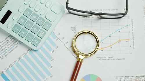 Documents with Magnifying Glass and Calculator