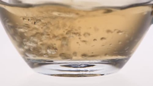 Gros plan. Le thé est versé dans une tasse en verre
